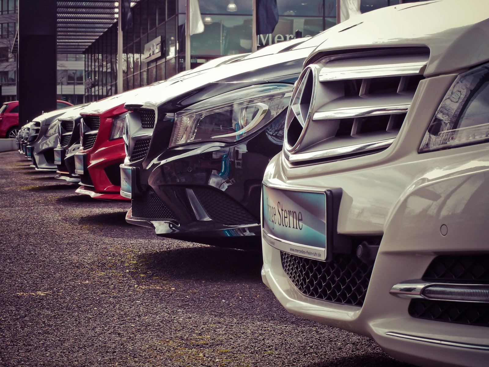 Kontakt 3 Luxury cars lined up at an outdoor dealership, showcasing sleek designs.